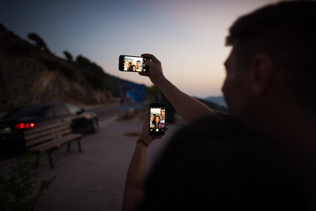 man holding smartphone during daytime