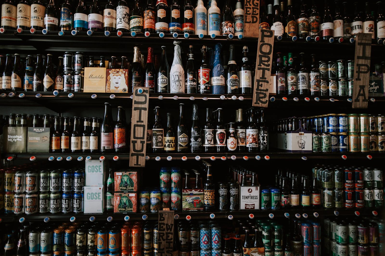 A wall stacked with hundreds of beer cans and bottles