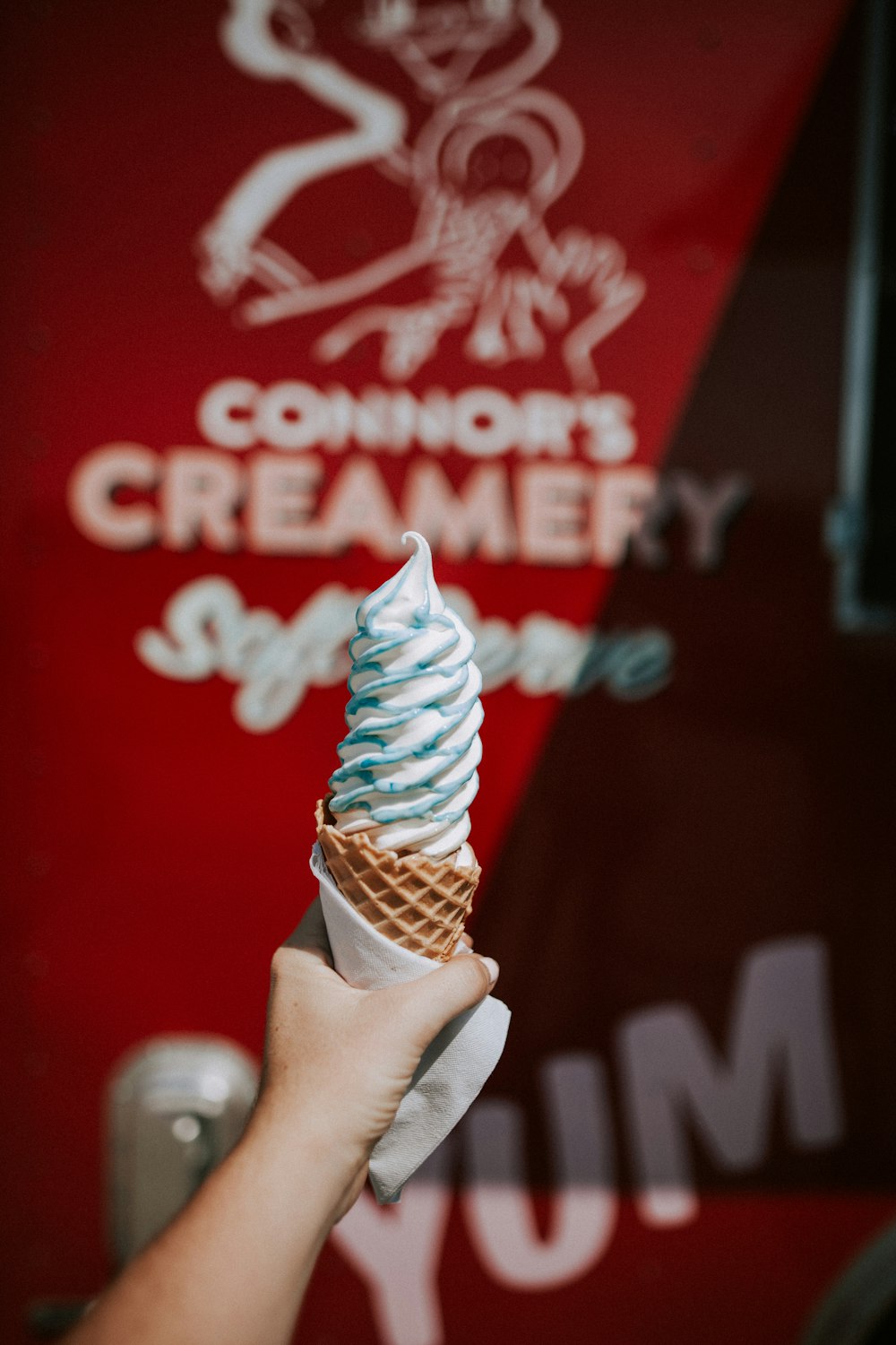 Persona sosteniendo un cono de helado en fotografía superficial