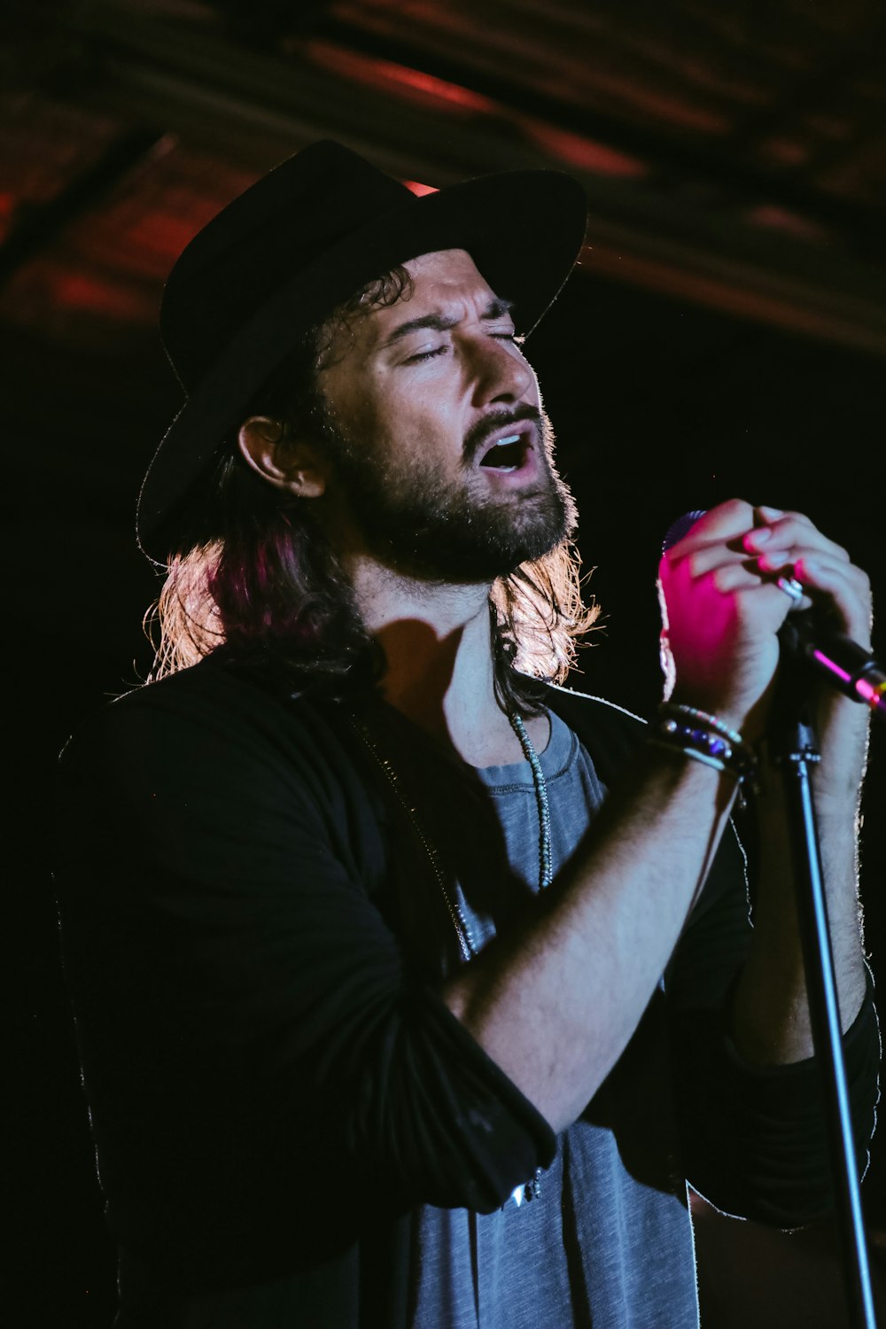 a man with long hair holding a microphone