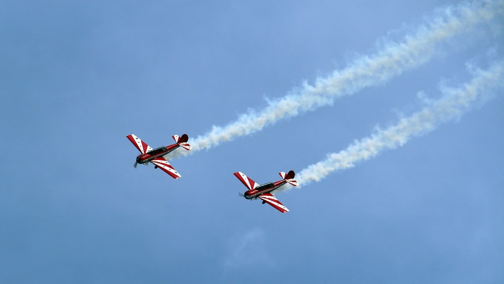 tow red-and-white planes under clear blue sky