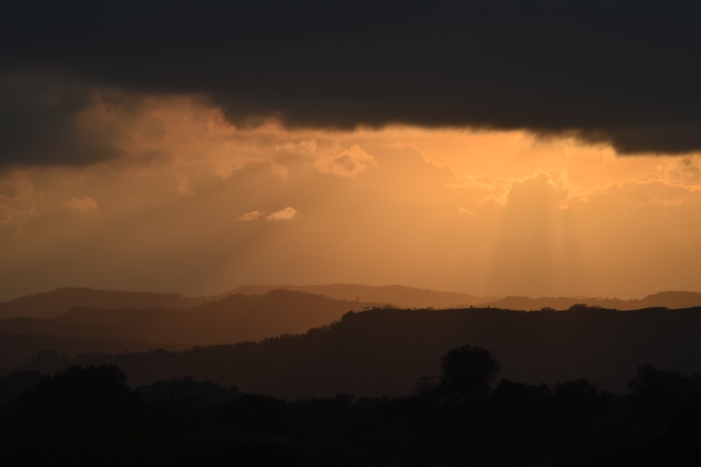 silhouette of mountain under black clouds