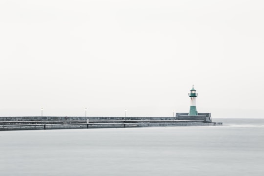 white and green lighthouse near body of water in Sassnitz Germany