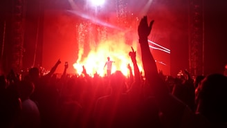 Glad X performing passionately on stage with vibrant city lights in the background.