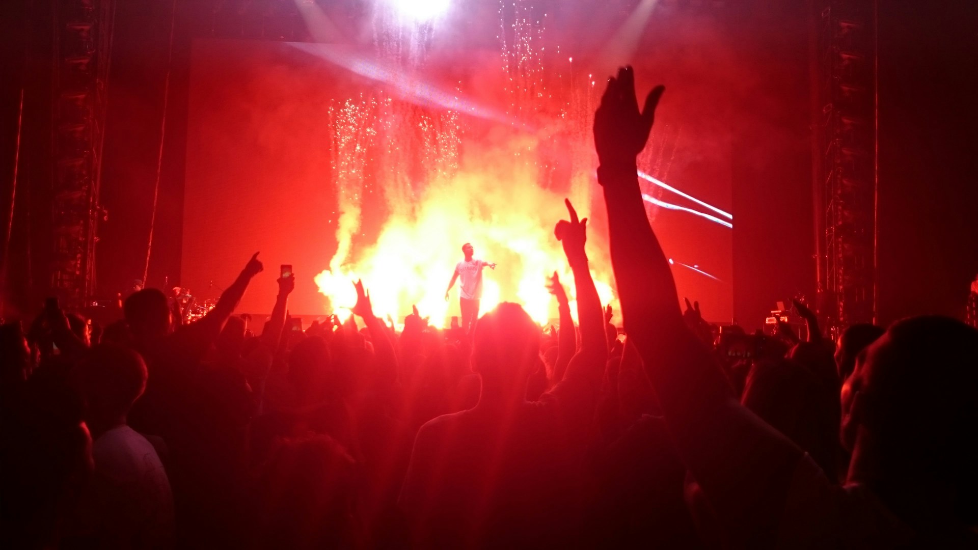 A vibrant live concert at GT Village with a crowd enjoying music under warm orange and red lights.