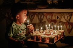 boy holding cupcake blowing the candle