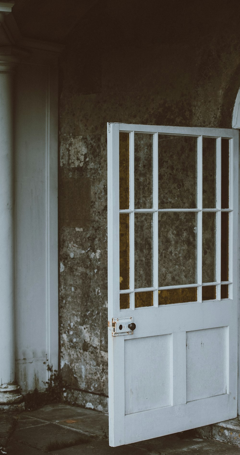 white steel door mounted on gray concrete wall