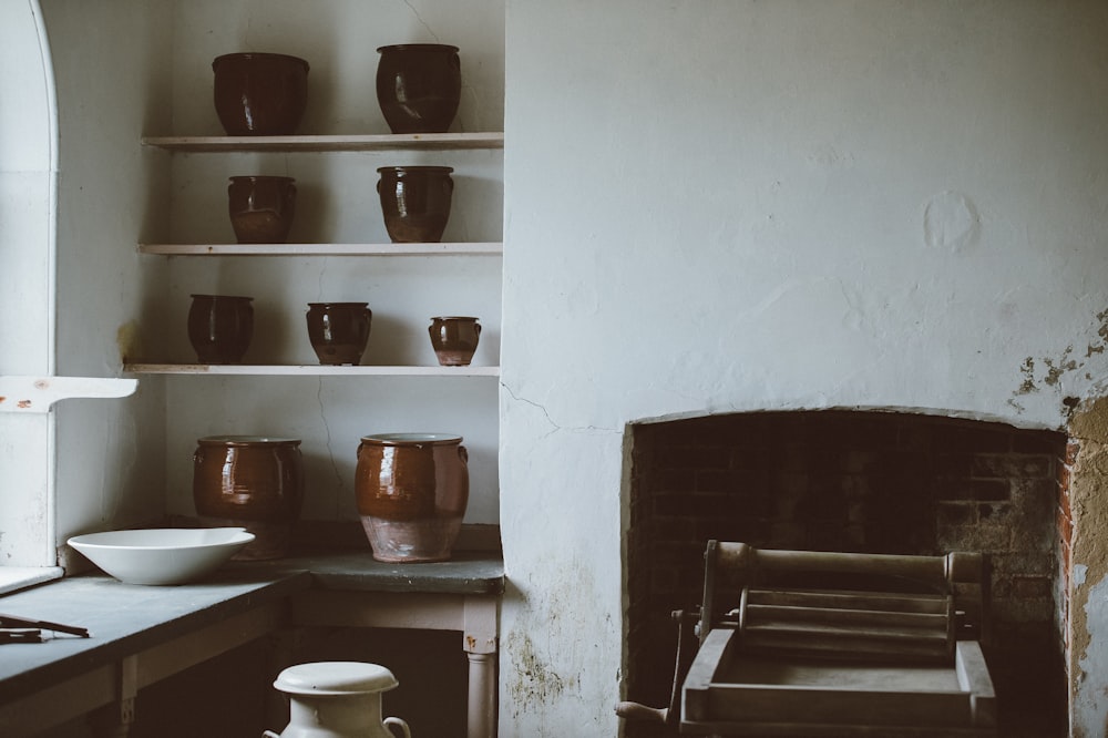 Foto de ollas de barro marrón en la rejilla de la cocina