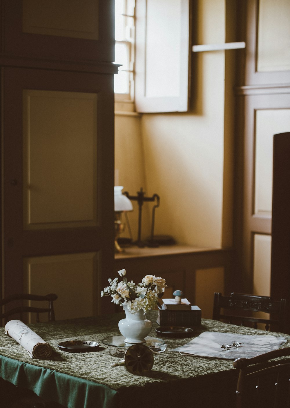 lowlight photography of white petaled flower with vase on table