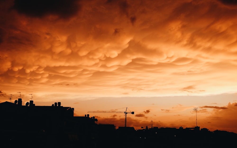 silhouette photo of buildings under the cloudy sky