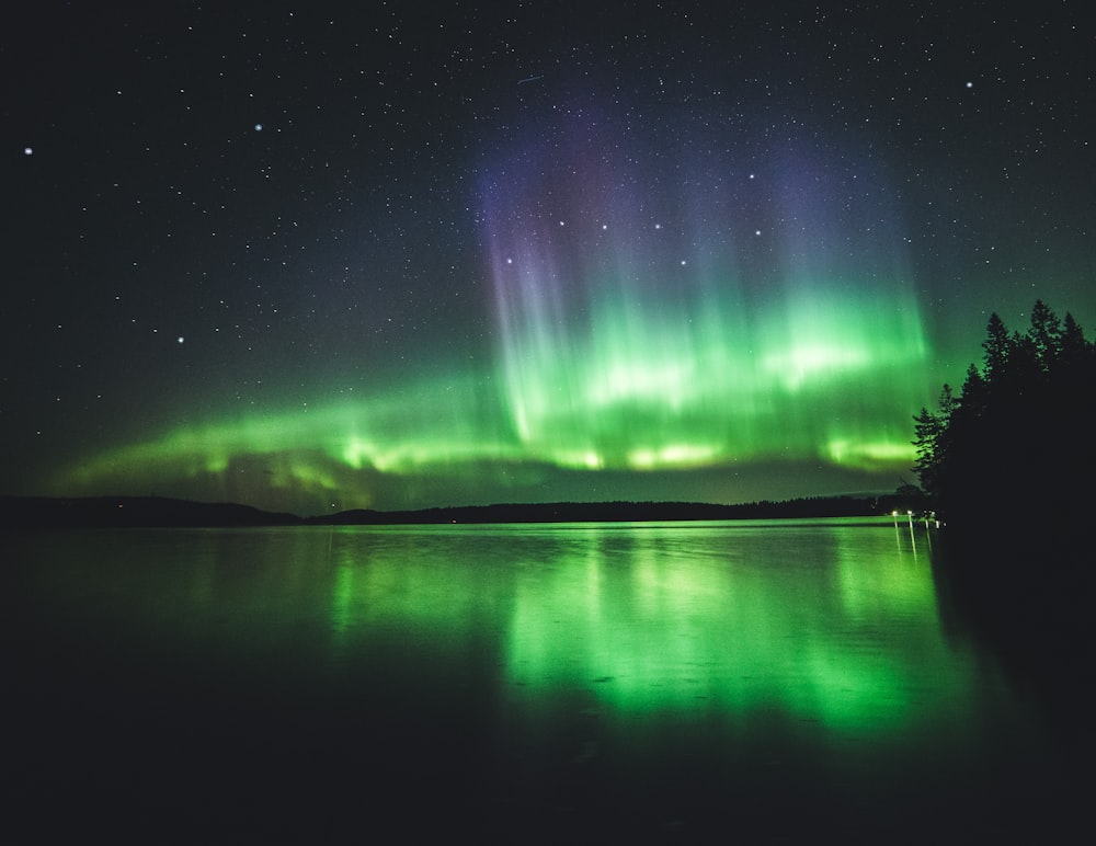 Corpo de água calmo sob luzes de aurora