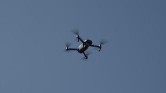 An instructor demonstrating drone operation to students outdoors with clear skies.