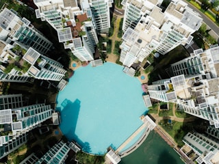 An aerial shot of a resort housing project featuring multiple modular steel homes arranged around a central pool.