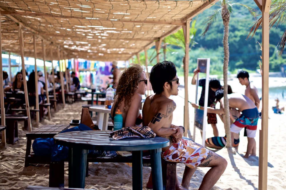 man and woman siting on seat in front of seashore