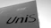 A large, flat, white building facade with the word 'UniS' in bold, black letters. The sky is clear and the perspective is from a low angle, emphasizing the height and simplicity of the structure.