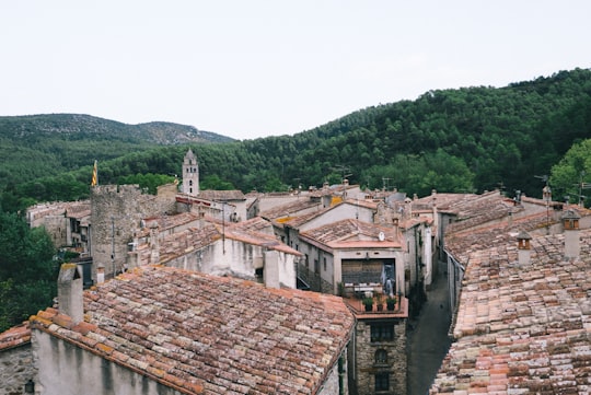 gray concrete houses surrounded by trees under gray sky in Sant Llorenç de la Muga Spain