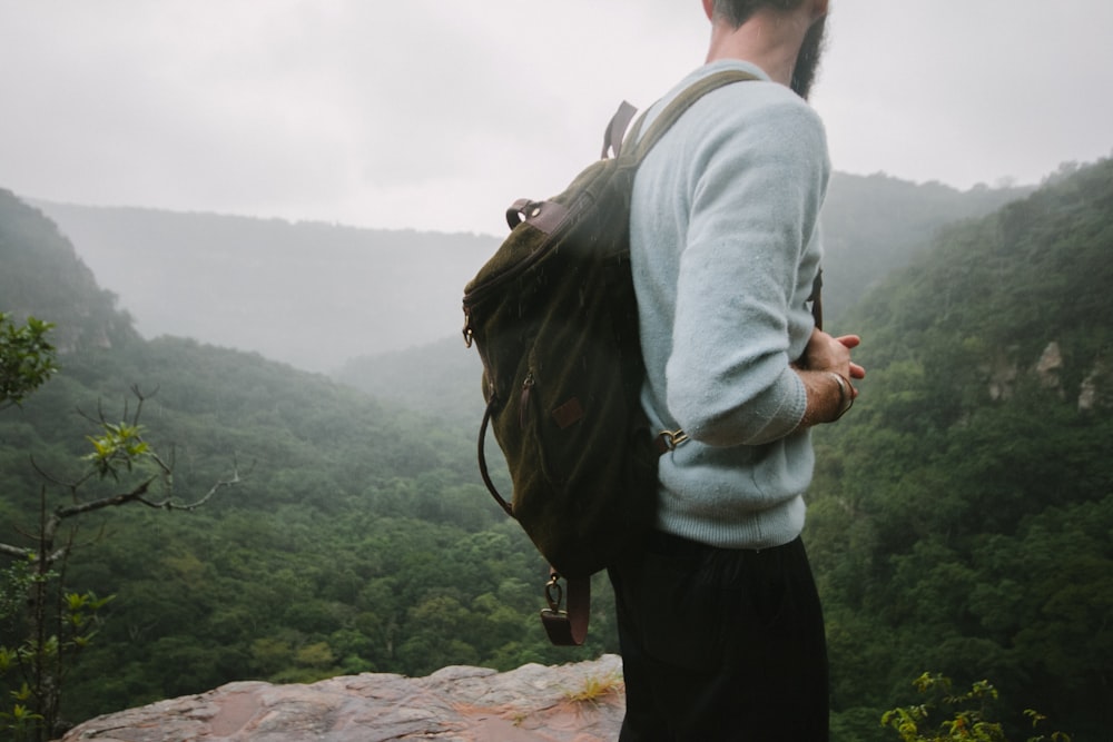 man standing on mountain top during day