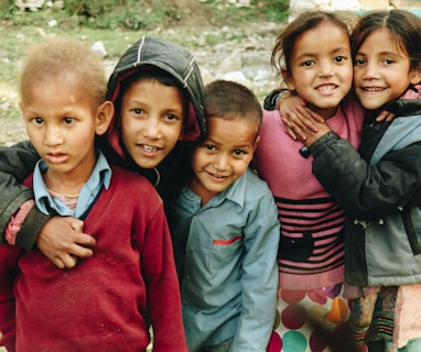 group of children standing on grass field during daytime