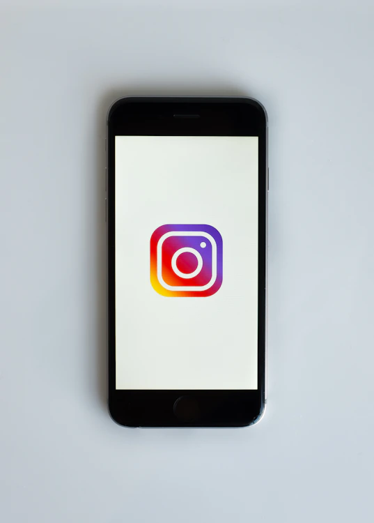 Smartphone com Instagram ao lado de laptop com site profissional para empresa em Curitiba