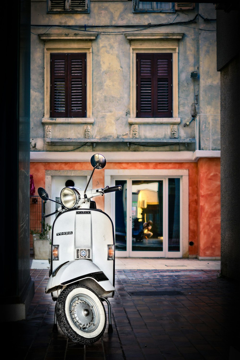 white motor scooter parked near building