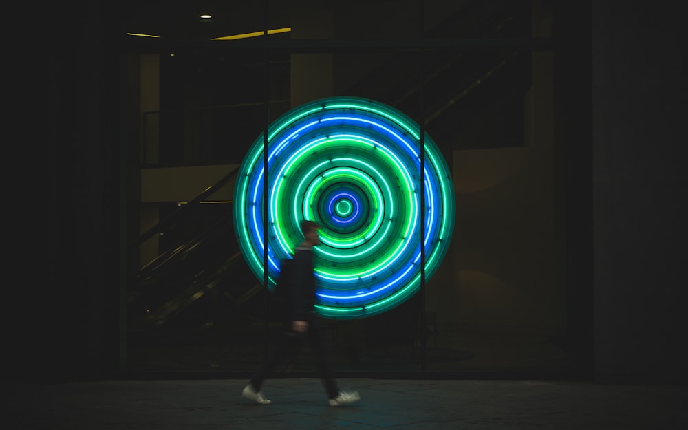 man walking near neon signage