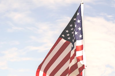 u.s.a. flag under cloudy sky during daytime stars and stripe teams background