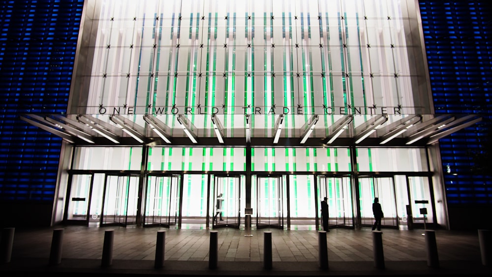 Photo d’un bâtiment en béton blanc, bleu et vert avec du verre