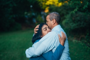 man hugging woman near trees