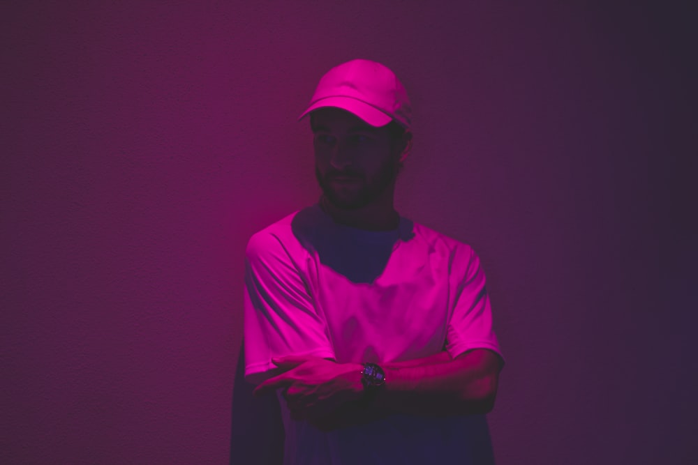 ファッション写真で紫色の光で壁に傾く男
