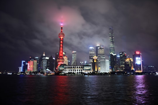 high rise buildings near body of water during nighttime in Pudong Skyline China