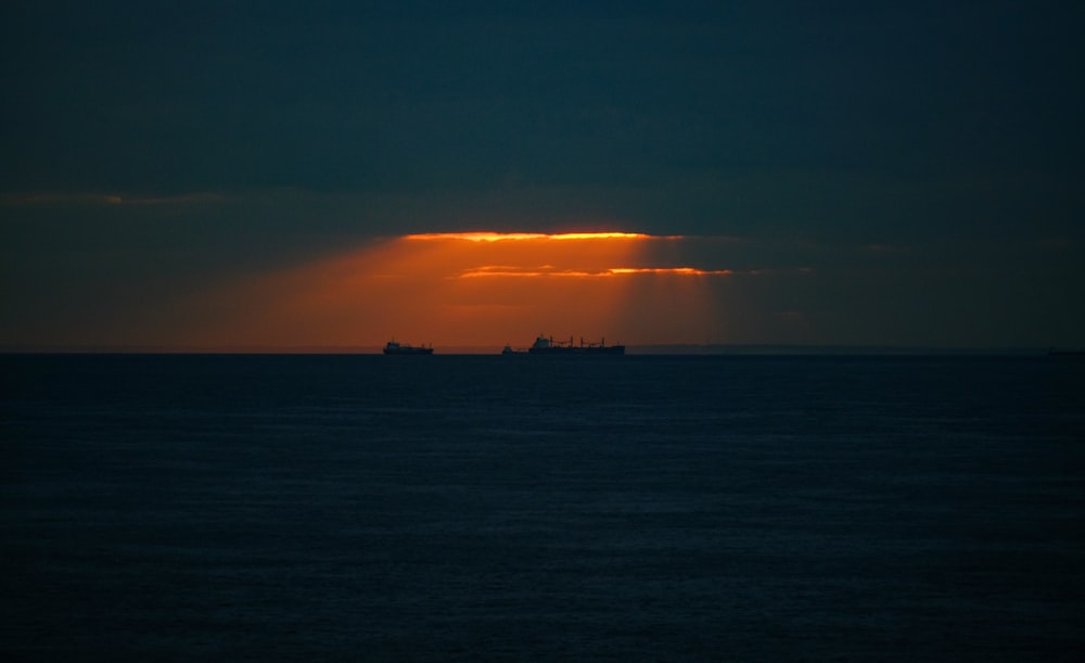 Silhouette de deux navires sur plan d’eau