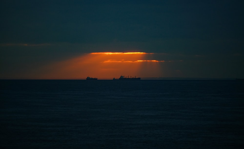 silhouette of two ships on body of water