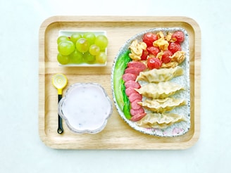 food on ceramic plates on square wooden tray