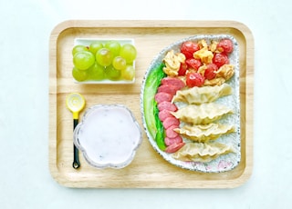 food on ceramic plates on square wooden tray