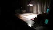 A calm, dark office environment with subtle lighting highlighting creative tools.