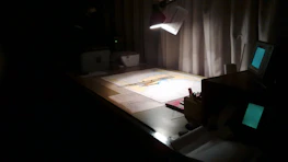 A calm, dark office environment with subtle lighting highlighting creative tools.