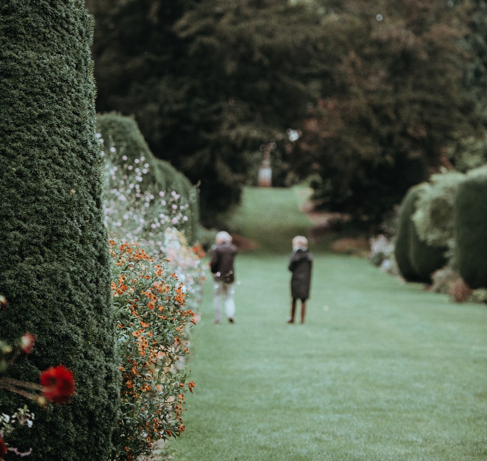 a couple of people that are standing in the grass