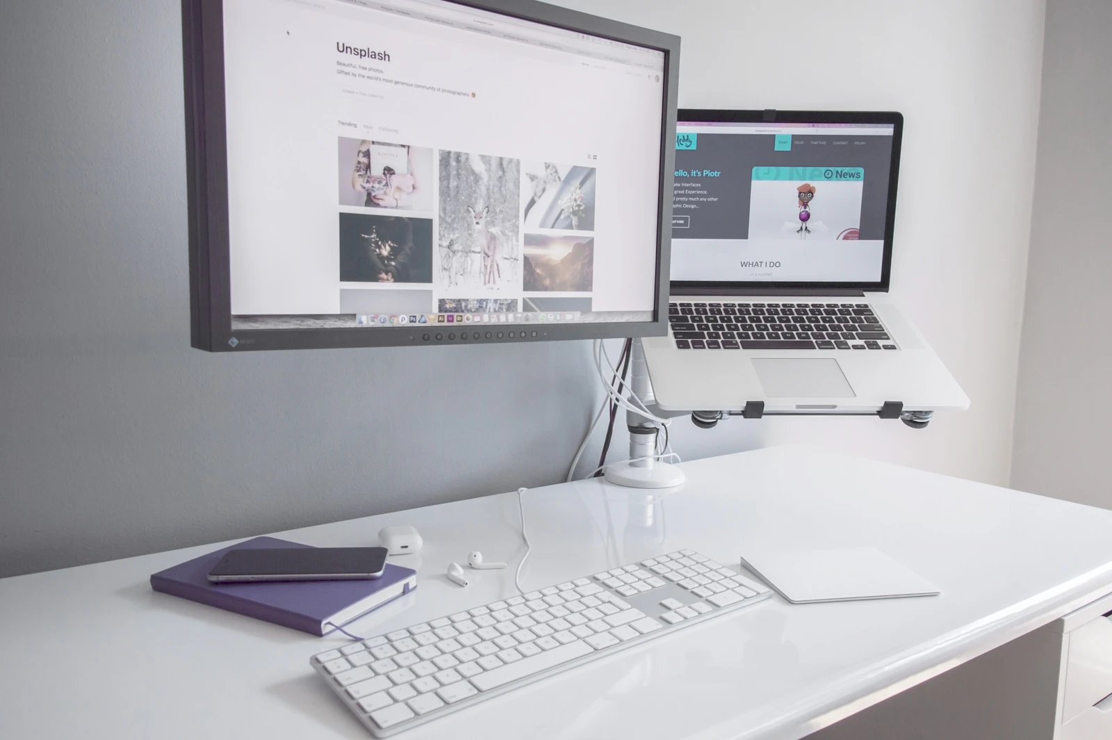 Silver dual VESA monitor arm holding a desktop display and a MacBook above a white desk with Magic Keyboard