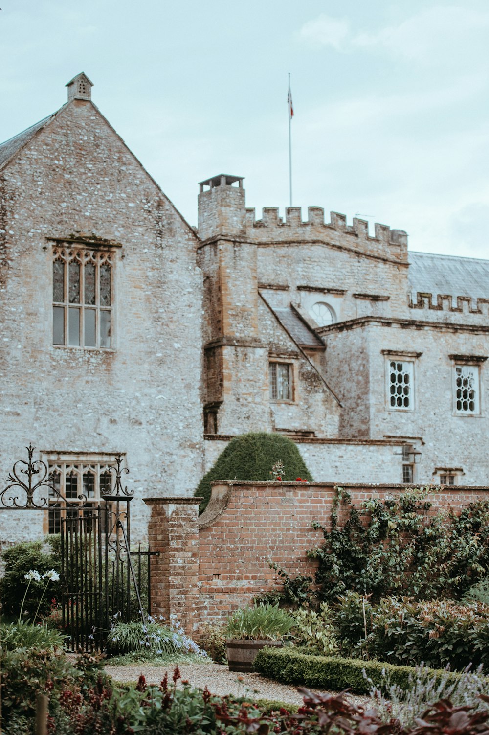 flower garden in front of brown castle at daytime