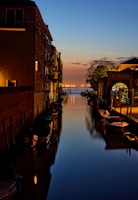 landscape photo of river with boats beside a building