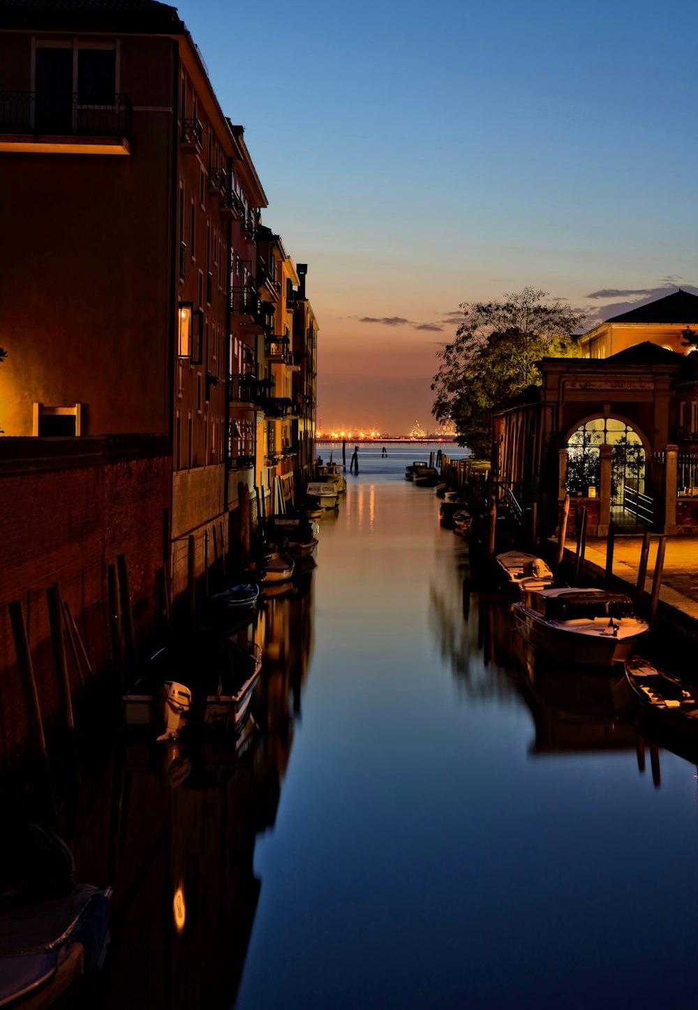 landscape photo of river with boats beside a building