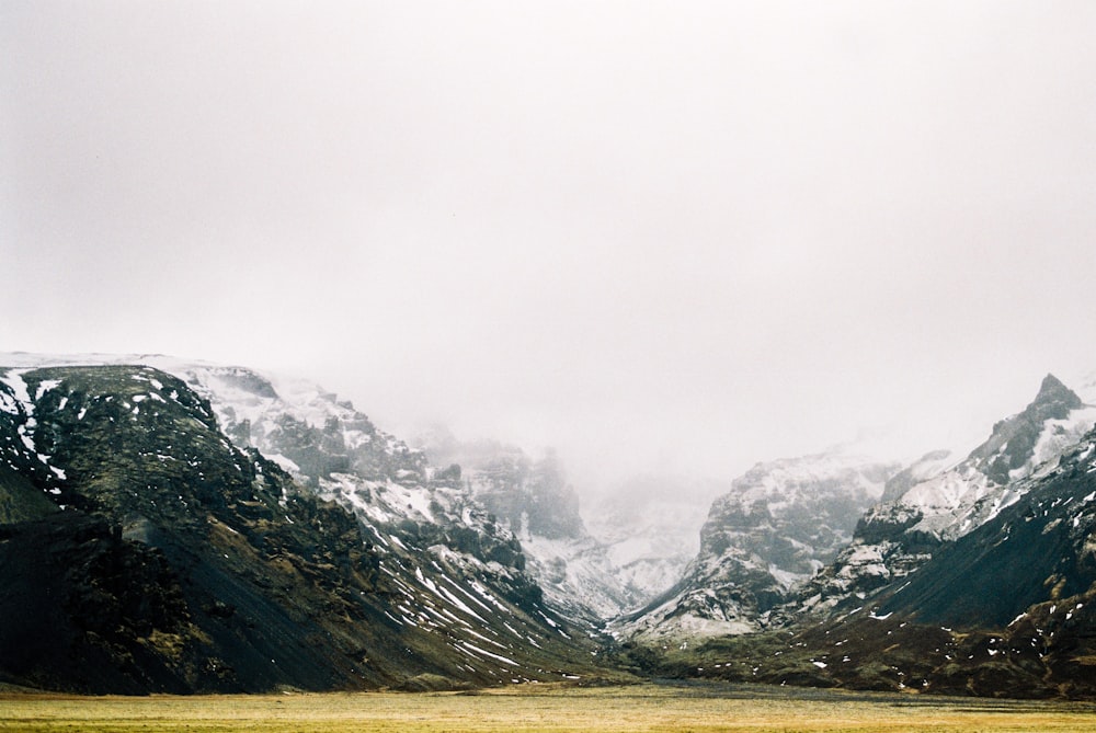 foto da paisagem da montanha coberta com neve e nevoeiro