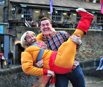 man standing on gray bridge while carrying a man during daytime