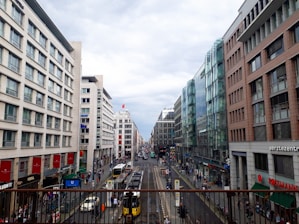 A bustling city street in Prishtina with people and modern buildings.