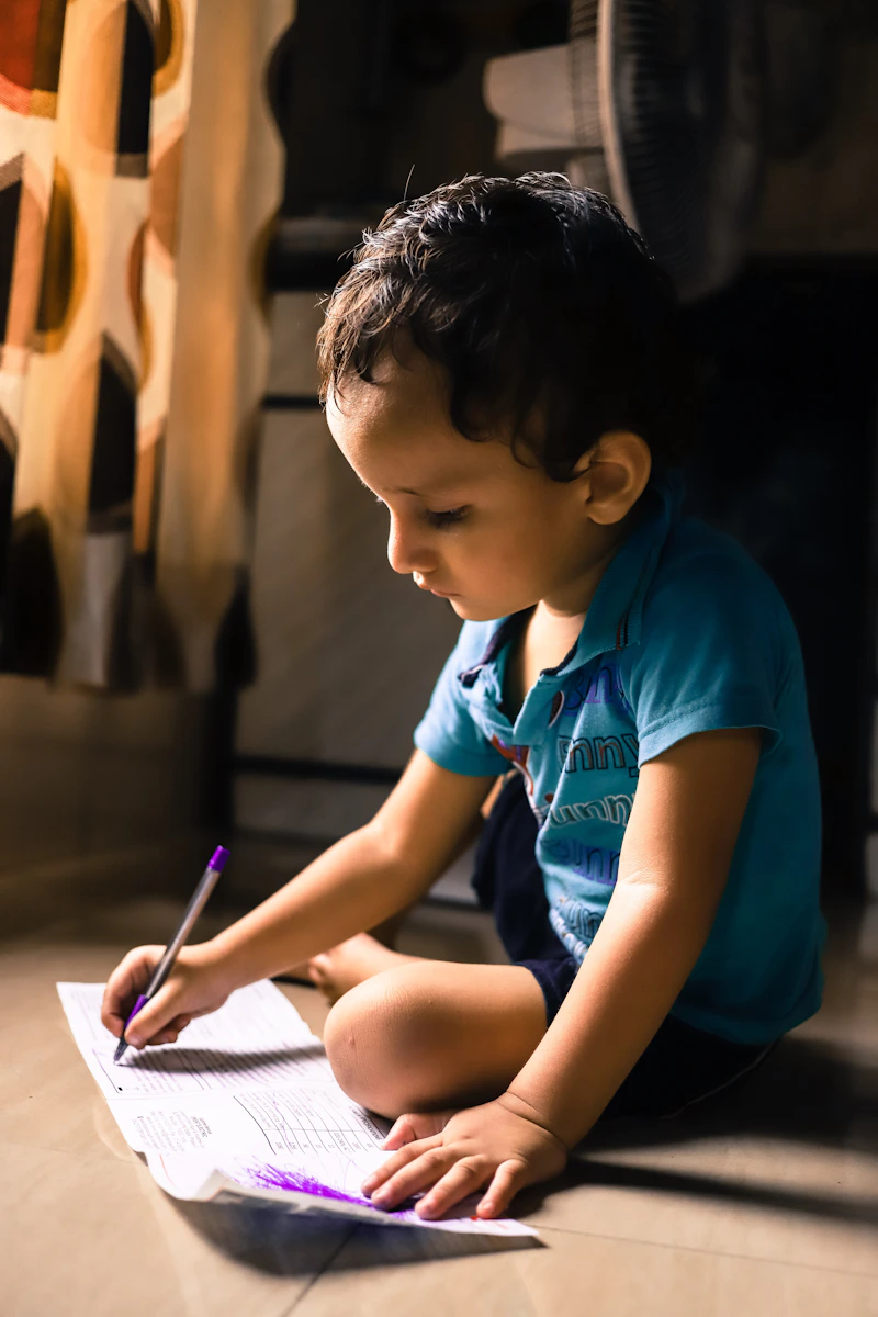 Child concentrating while writing, carefully forming letters