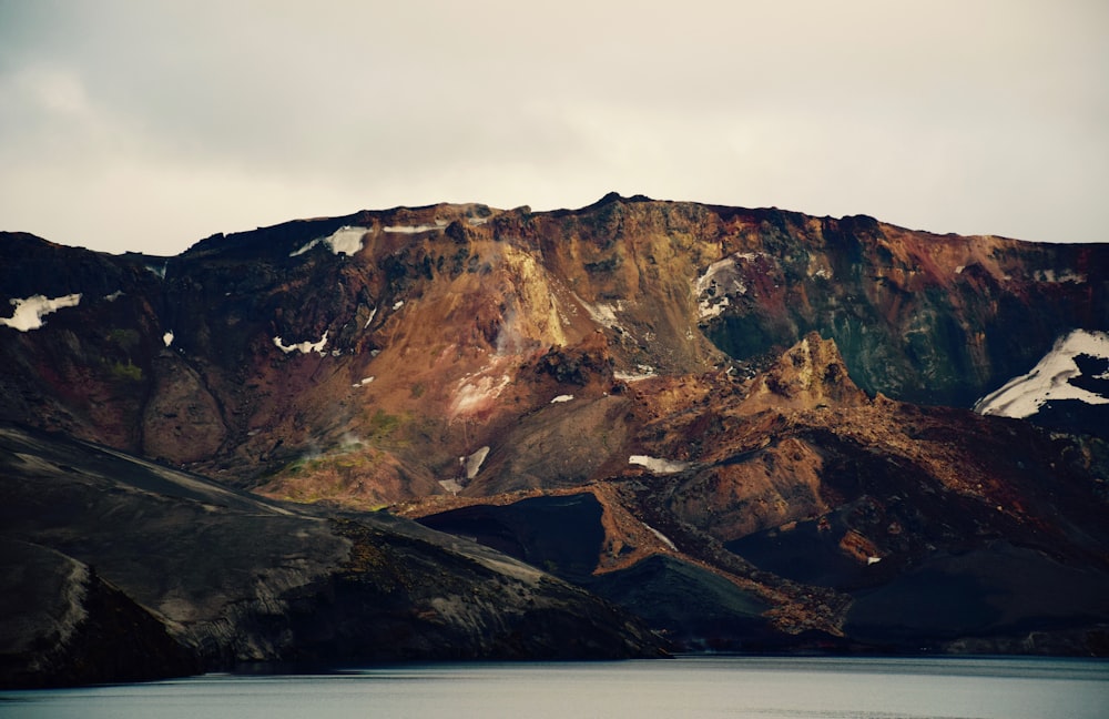 photo of mountain under white sky