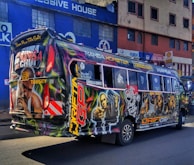 A street-level view of a bus wrapped in a bold, eye-catching advertisement.