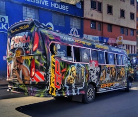 A busy urban bus wrapped with colorful advertising graphics.