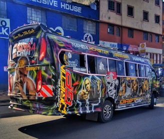 A street-level view of a bus wrapped in a bold, eye-catching advertisement.