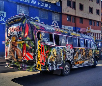 A colorful bus wrapped in advertising cruising through a busy Mumbai street.